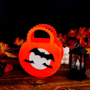 Halloween felt candy bag detail showing cute black bats and white moon on orange tote texture.
