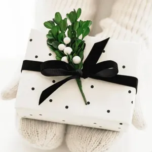 Detailed view of a beautifully wrapped gift box with polka dot paper and black velvet ribbon.