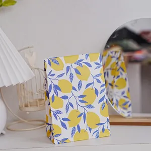 Lemon pattern paper gift bag detail shot, featuring fresh yellow fruit print and delicate blue leaves.
