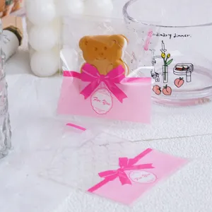 Detailed close-up of pink bow cookie packaging bags, showing clear food-grade plastic design.