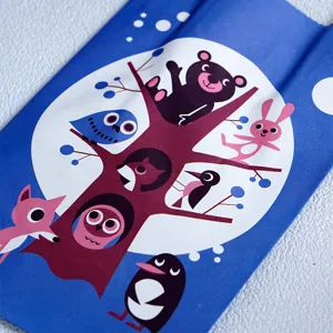 Close-up detail of blue kraft paper gift bag featuring cute forest animal cartoon illustration.