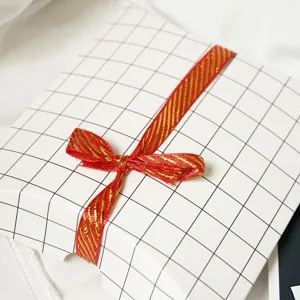 Rot-gold gewebtes Zierband mit weißer Karo-Schachtel-Detail für Geschenkverpackung.