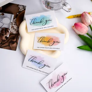 Detail shot of pastel watercolor thank you business cards with elegant calligraphy font.