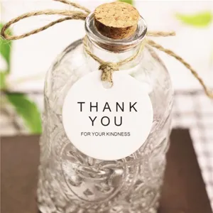 Detailed shot of vintage glass bottle with cork stopper, twine rope and thank you hang tag.