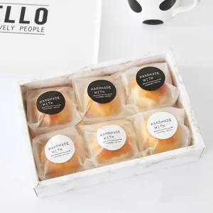 Caja de regalo de mármol con seis pasteles envueltos individualmente y pegatinas artesanales.
