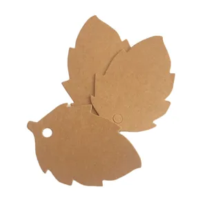 Detailed view of leaf shaped kraft paper tags, blank gift cards for DIY crafts and jewelry.