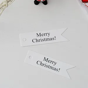 Close up detail of white paper Christmas swallowtail hanging tags with Merry Christmas text.