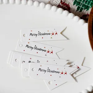 Christmas gift tags detail shot, white swallowtail paper tag with Merry Christmas text.