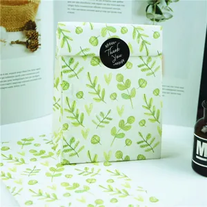 Detalle de la bolsa de papel de regalo con patrón de hojas verdes, embalaje plano ecológico.