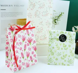 Bolsas de regalo de papel floral con cinta roja y pegatina de agradecimiento para pastelería.