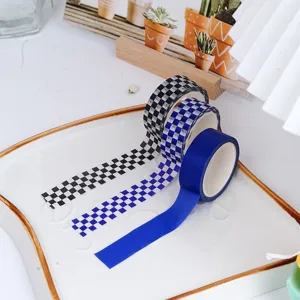 Nahaufnahme von karierten Klein-Blau-Abdeckbändern auf einem weißen Tablett für Bastelarbeiten.