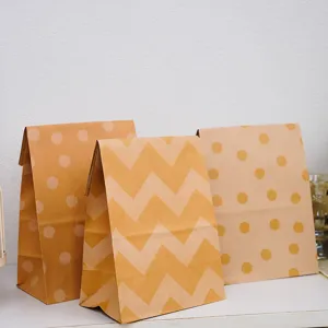Sacchetti regalo in carta kraft a pois e motivi chevron, design pieghevole senza manici.
