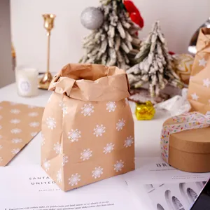 Sacchetto regalo in carta kraft vintage con motivo a fiocco di neve bianco per le feste.
