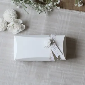 Boîte cadeau oreiller blanche avec ruban en dentelle et fleur pour nougat et biscuits.