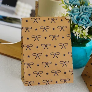 Bolsa de regalo de papel kraft marrón con lazo azul y estampado de estrellas para detalles.