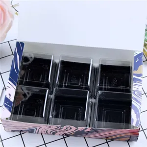 Détail de boîte d'emballage à 6 grilles, couvercles d'dôme transparents et bases noires en marbre.