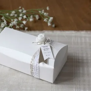Detail de boîte cadeau en papier blanc avec joli ruban de dentelle et étiquette.