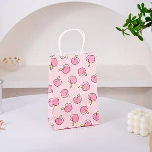 Piccolo sacchetto regalo in carta rosa con motivo di pesche e manici bianchi per feste e caramelle.