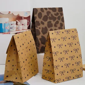 Detalle de bonitas bolsas de papel kraft con motivos de lazos y estrellas para empaque de regalos.