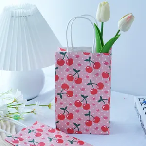 Vista dettagliata di un piccolo sacchetto regalo in carta rosa con motivo a ciliegie.