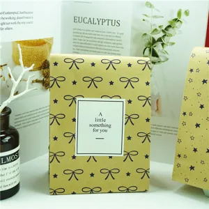 Detalle de bolsa de regalo de papel kraft, diseño de lazo y estrellas, sobre ecológico