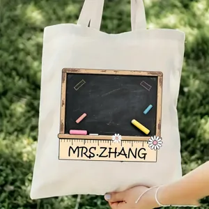 Vista detallada de bolso tote de lona para profesores con estampado de pizarra y gran capacidad.