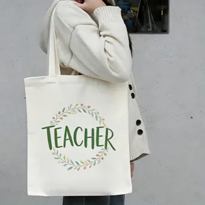 Detailweergave van de canvas tas met leraar tekst en bloemenkrans patroonontwerp.