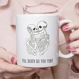 Nahaufnahme der weißen Keramik Kaffeetasse mit süßem gotischen Skelett Pärchen Motiv.