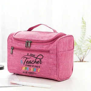 Detail view of pink teacher toiletry bag with quote print, handle and double zipper closure.