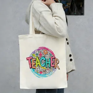 Gedetailleerd overzicht van canvas shopper tas met kleurrijke leraar print en ontwerp.