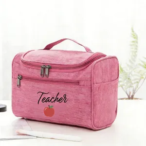 Pink teacher cosmetic bag detail, featuring cute apple print and portable handle for travel.
