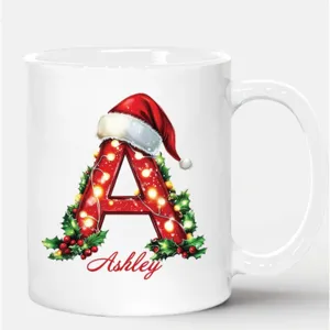 Taza de café de cerámica navideña con letra inicial y nombre personalizado festivo.