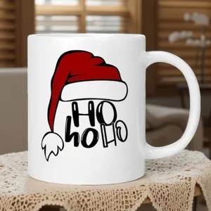 Detailansicht der weißen Keramiktasse mit Weihnachtsmütze und HO HO HO Aufdruck für heiße Getränke.