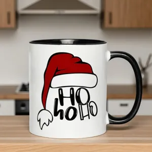 Weihnachtlicher Keramik Kaffebecher mit schwarzem Henkel und Weihnachtsmann-Mütze für Heißgetränke.