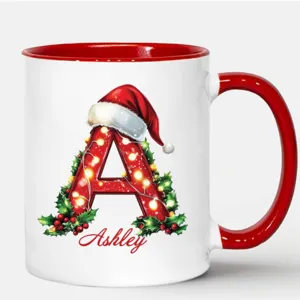 Detalle de taza navideña personalizada con gráfico de gorro de papá Noel y nombre impreso.