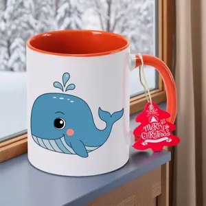 Schattige blauwe walvis keramische koffiekop met oranje handvat en feestelijk kerstlabel.