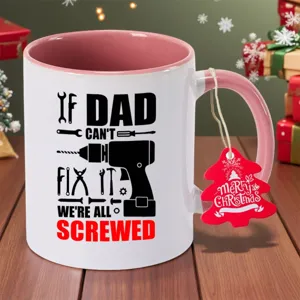 Detail view of pink and white ceramic coffee mug with funny dad tool graphics and Christmas tag.