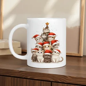 Close-up detail of a white ceramic coffee mug featuring a cute Christmas cat tree design.