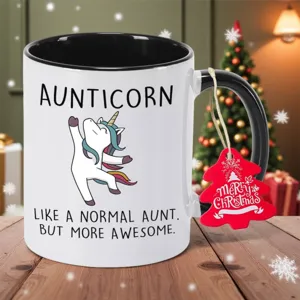 Detailansicht der Keramiktasse mit Einhorn Motiv und rotem Weihnachtsbaumanhänger.