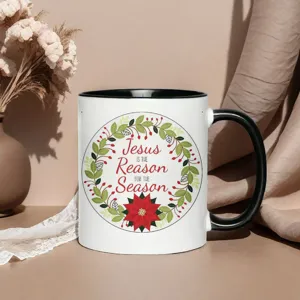 Ceramic coffee mug detail showing festive Christmas wreath and religious quote print clearly.