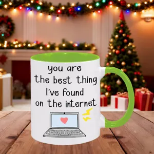 Detailansicht der weißen Keramiktasse mit grünem Henkel und romantischem Zitat.