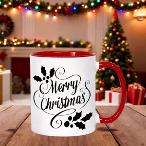 Detailaufnahme der weihnachtlichen Keramiktasse mit rotem Henkel auf einem Holztisch.