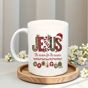 Close-up detail of white ceramic coffee mug featuring festive holiday typography print.