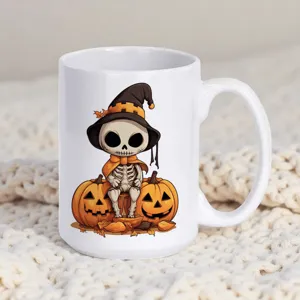 Detailansicht einer weissen Keramiktasse mit einem süessen Skelett und Kürbis Design.