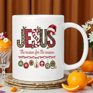 Detail shot of white ceramic Christmas coffee mug with festive religious text and holiday theme.