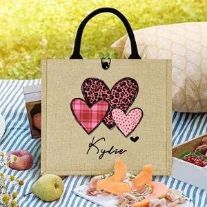 Personalized jute tote bag with cute heart patterns and custom name, ideal for daily use and gifts.