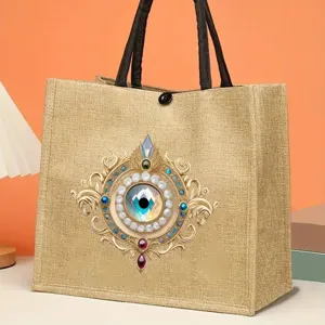 Mystical evil eye jute tote bag with detailed vintage filigree design, perfect daily handbag.