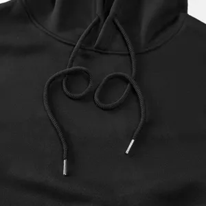 Close-up detail of black hoodie drawstring and metal aglet, soft fabric texture.