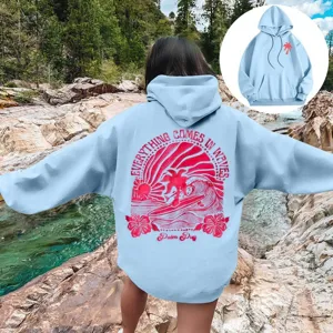 Sweat à capuche décontracté bleu clair pour femme avec épaules et imprimé rose.