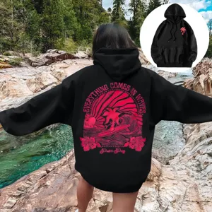 Sweat à capuche noir décontracté avec épaules tombantes et impression de surf rose au dos.
